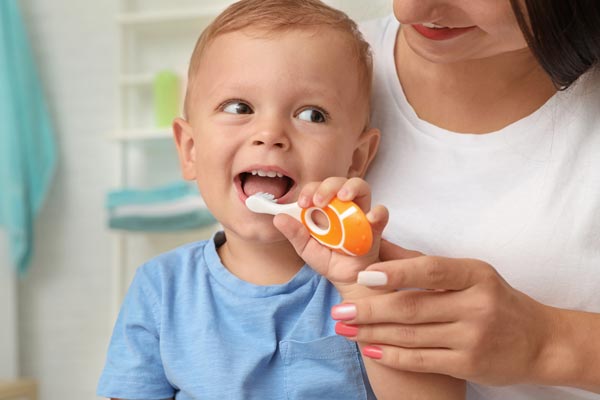 Children holding toothbrush with her mother